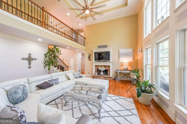 4408 Meadowwood Dr, Loganville, GA 30052 - living area featuring stairs, a towering ceiling, wood finished floors, a ceiling fan, and a stone fireplace