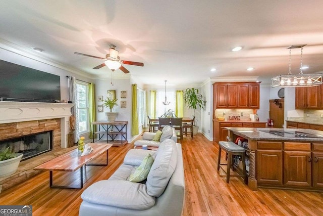 4408 Meadowwood Dr, Loganville, GA 30052 - living room with a fireplace, light wood-style flooring, ceiling fan, and ornamental molding