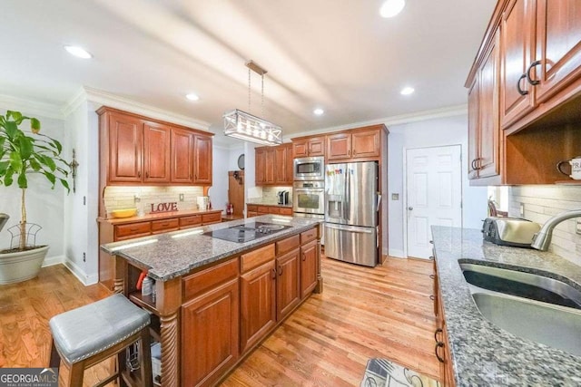 4408 Meadowwood Dr, Loganville, GA 30052 - kitchen with crown molding, a sink, dark stone countertops, stainless steel appliances, and light wood-style floors