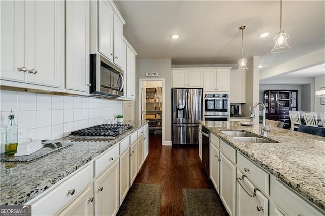 4870 Odum View Ln, Cumming, GA 30040 - kitchen featuring stainless steel appliances, dark wood finished floors, pendant lighting, backsplash, and white cabinets