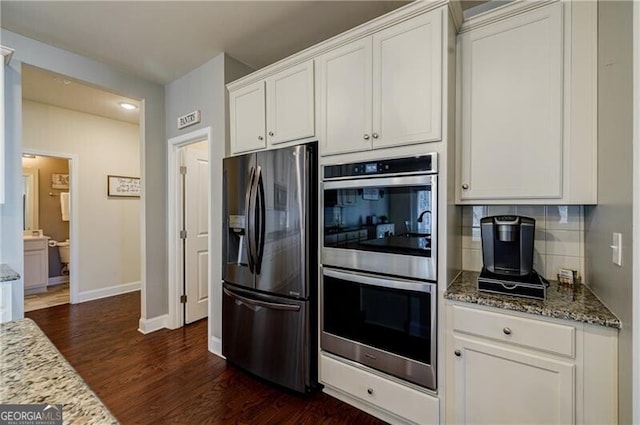 4870 Odum View Ln, Cumming, GA 30040 - kitchen featuring appliances with stainless steel finishes, dark wood-style flooring, light stone counters, white cabinets, and tasteful backsplash