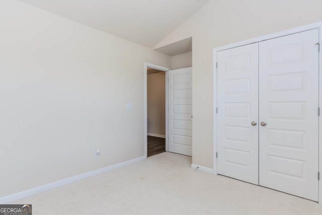 3627 Canyon Springs Dr, Oakwood, GA 30566 - unfurnished bedroom featuring lofted ceiling, baseboards, a closet, and light colored carpet