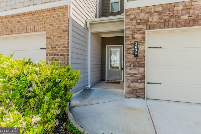 3627 Canyon Springs Dr, Oakwood, GA 30566 - view of exterior entry featuring stone siding, brick siding, and a garage