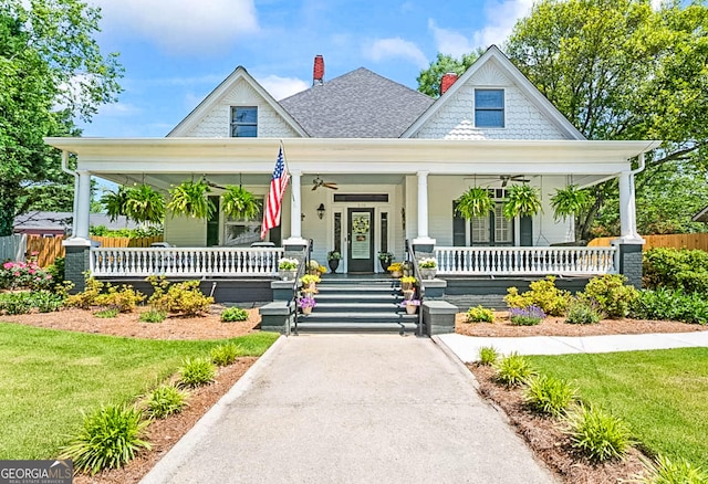 2173 Conyers St SE, Covington, GA 30014 - view of front of home with covered porch, ceiling fan, a chimney, and a shingled roof
