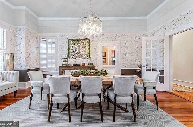 2173 Conyers St SE, Covington, GA 30014 - dining area featuring healthy amount of natural light, a chandelier, dark wood-style floors, ornamental molding, and wallpapered walls