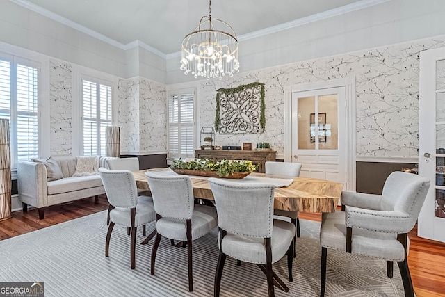 2173 Conyers St SE, Covington, GA 30014 - dining area with wood finished floors, a chandelier, ornamental molding, and wallpapered walls