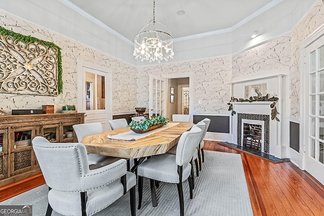 2173 Conyers St SE, Covington, GA 30014 - dining space with wood-type flooring, a chandelier, a fireplace, and ornamental molding