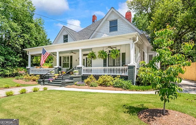 2173 Conyers St SE, Covington, GA 30014 - view of front of house featuring a porch, a ceiling fan, a front yard, and a chimney