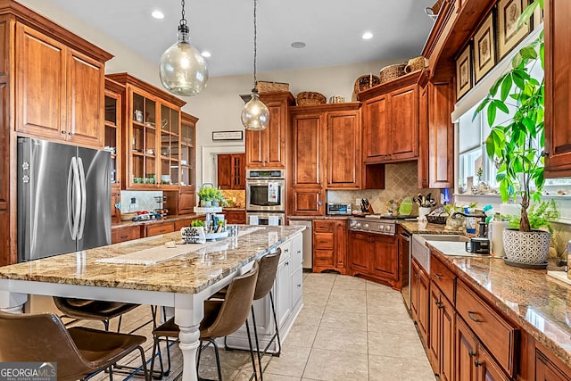 2173 Conyers St SE, Covington, GA 30014 - kitchen featuring appliances with stainless steel finishes, decorative backsplash, a kitchen breakfast bar, a kitchen island, and recessed lighting