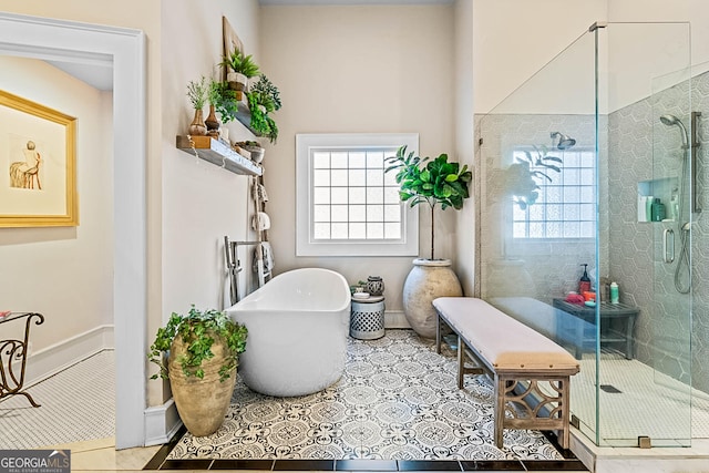 2173 Conyers St SE, Covington, GA 30014 - full bathroom with plenty of natural light, a stall shower, tile patterned floors, and a soaking tub
