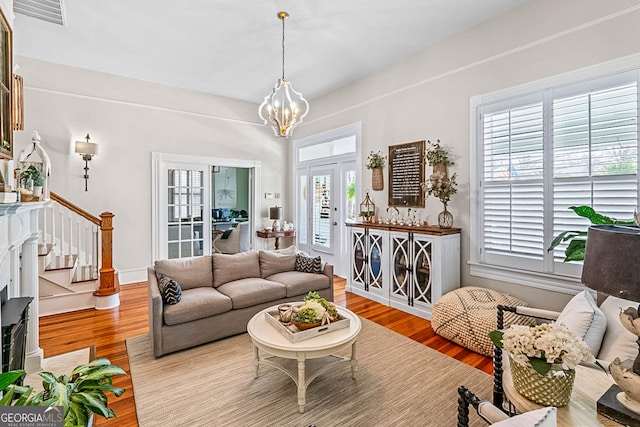 2173 Conyers St SE, Covington, GA 30014 - living room featuring healthy amount of natural light, a chandelier, stairway, and wood finished floors