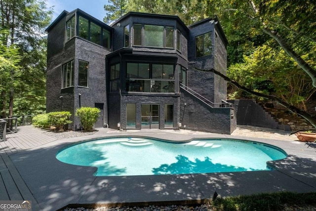 4 W Wesley Rdg NW, Atlanta, GA 30327 - rear view of property featuring an outdoor pool, a deck, a patio area, and stone siding