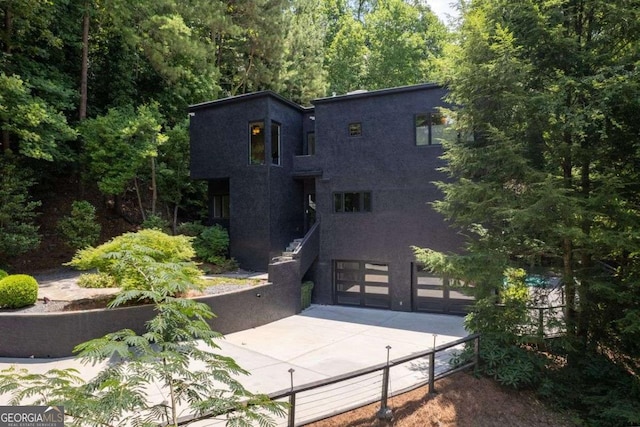 4 W Wesley Rdg NW, Atlanta, GA 30327 - rear view of house featuring driveway, a garage, and stucco siding