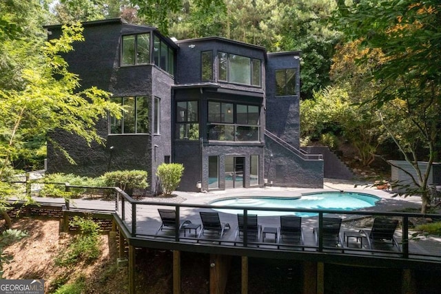 4 W Wesley Rdg NW, Atlanta, GA 30327 - back of property with stairway, an outdoor pool, stucco siding, and a deck