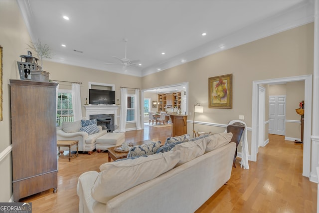 11 Creekwood Dr, Dublin, GA 31021 - living room featuring light wood finished floors, ornamental molding, recessed lighting, a ceiling fan, and a glass covered fireplace