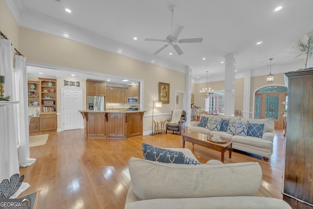 11 Creekwood Dr, Dublin, GA 31021 - living area featuring ceiling fan with notable chandelier, decorative columns, crown molding, and light wood-type flooring