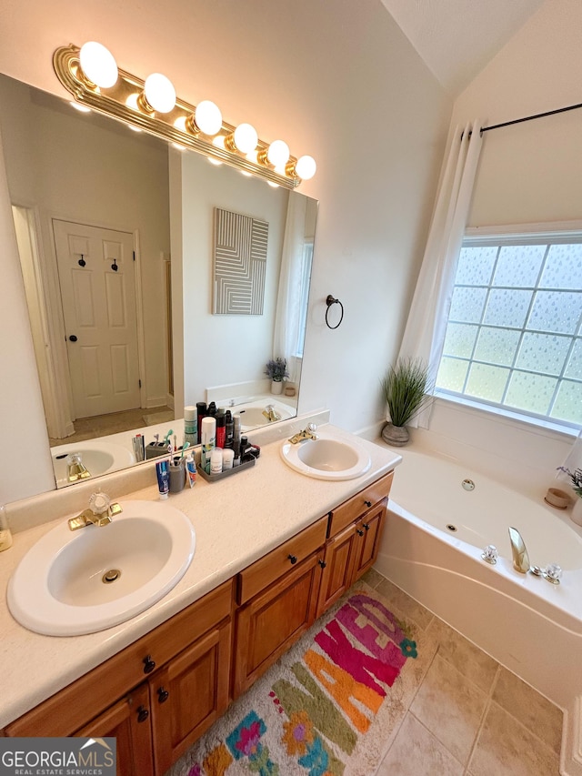924 Morningside Dr, Griffin, GA 30224 - bathroom featuring tile patterned floors, a bath, double vanity, and vaulted ceiling