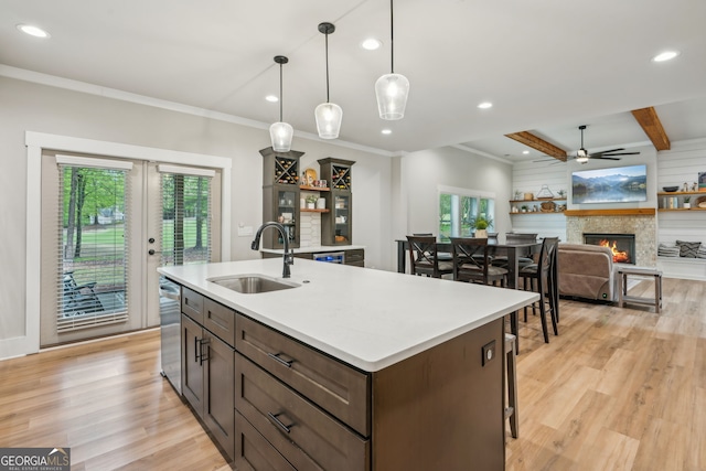 4426 Oxburgh Park, Flowery Branch, GA 30542 - kitchen with a warm lit fireplace, light wood finished floors, dark brown cabinets, recessed lighting, and light countertops