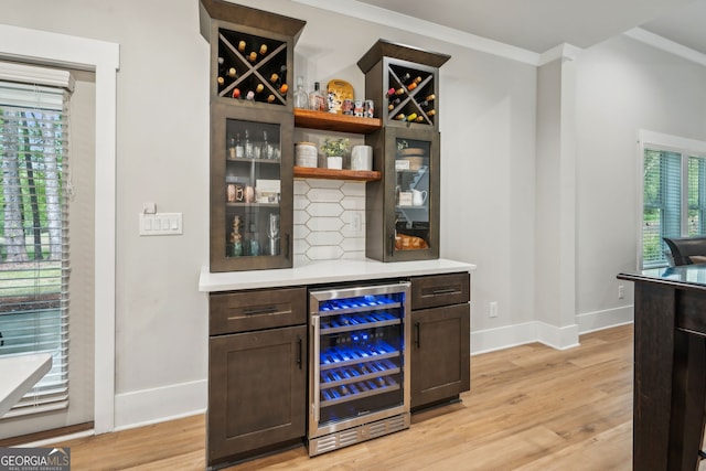 4426 Oxburgh Park, Flowery Branch, GA 30542 - indoor dry bar featuring beverage cooler, light wood finished floors, decorative backsplash, and ornamental molding