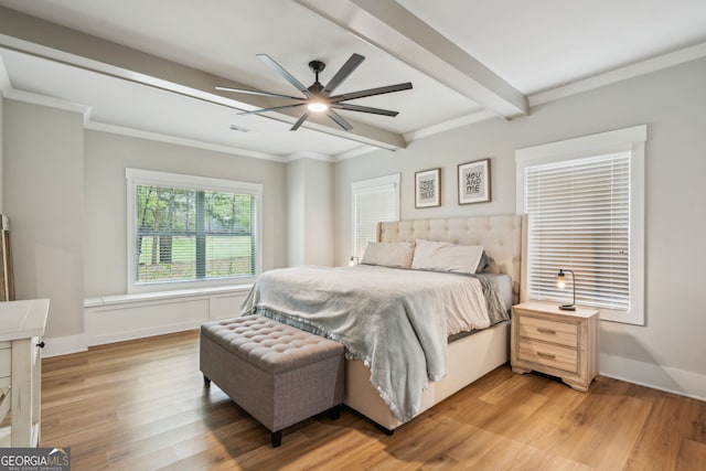 bedroom with visible vents, beamed ceiling, crown molding, light wood-style flooring, and ceiling fan