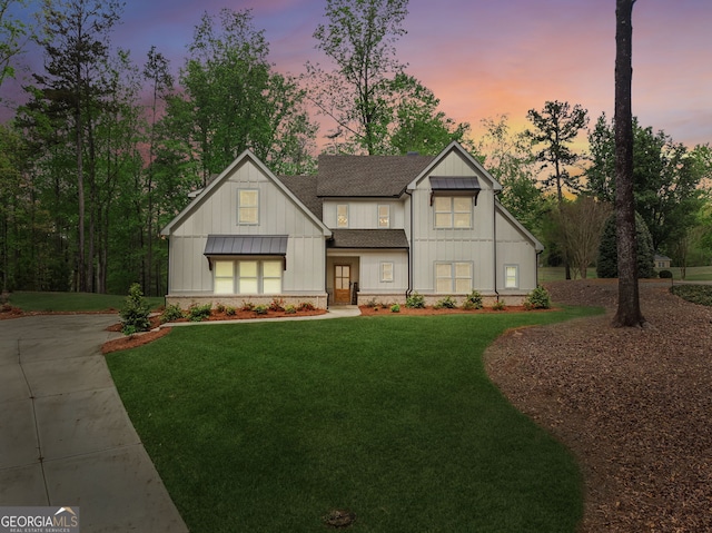 modern inspired farmhouse featuring a front lawn, roof with shingles, and board and batten siding