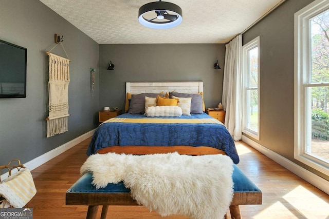 4295 S Berkeley Lake Rd NW, Berkeley Lake, GA 30096 - bedroom featuring a textured ceiling and wood finished floors