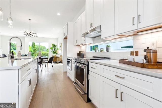 2029 Memorial Dr Unit 32, Atlanta, GA 30317 - kitchen featuring under cabinet range hood, stainless steel range with electric cooktop, a sink, tasteful backsplash, and recessed lighting