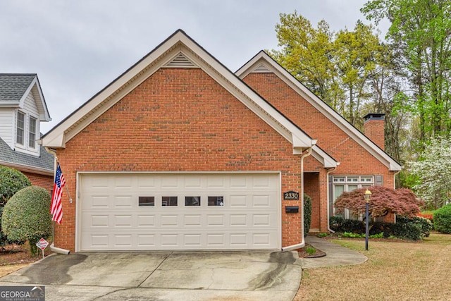 traditional-style home featuring driveway, brick siding, a chimney, and a front yard