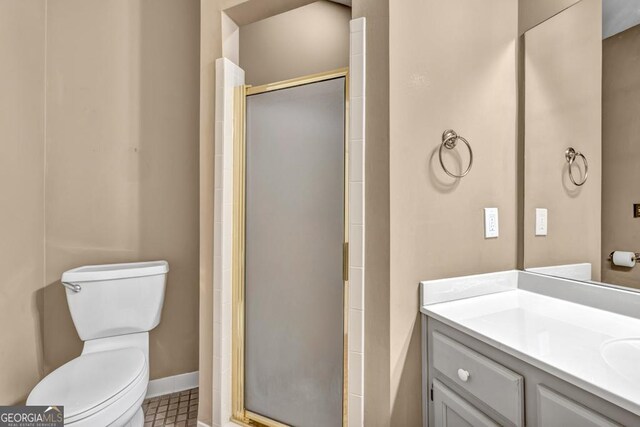 full bathroom featuring vanity, baseboards, toilet, and a shower stall
