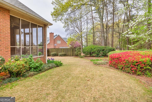 view of yard with a sunroom and fence