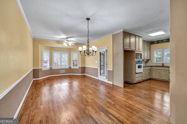 kitchen with a chandelier, a sink, oven, and wood finished floors