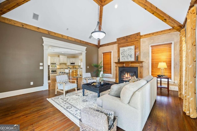1462 Georgia Club Dr, Statham, GA 30666 - living room featuring dark wood-style flooring, baseboards, beamed ceiling, visible vents, and a glass covered fireplace