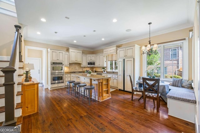 1462 Georgia Club Dr, Statham, GA 30666 - kitchen with tasteful backsplash, stainless steel appliances, a chandelier, cream cabinets, and dark wood-style floors