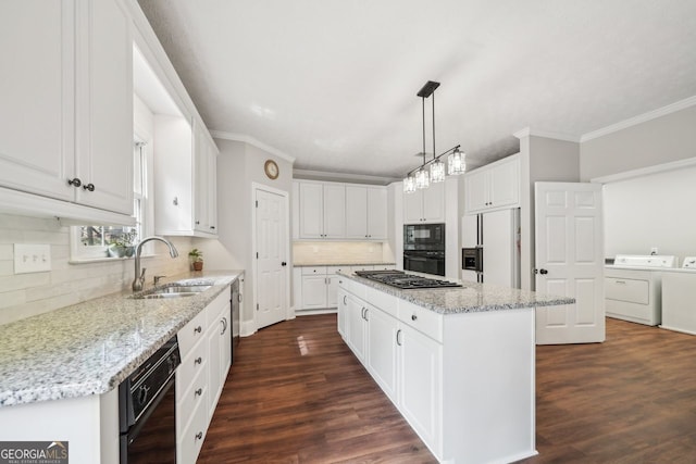 740 Trillium Ln, Lilburn, GA 30047 - kitchen with washer and dryer, black appliances, a sink, ornamental molding, and a kitchen island