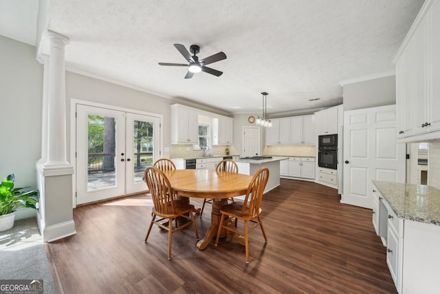 740 Trillium Ln, Lilburn, GA 30047 - dining area featuring ornate columns, a textured ceiling, a ceiling fan, ornamental molding, and dark wood-style flooring
