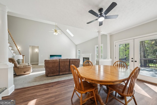 740 Trillium Ln, Lilburn, GA 30047 - dining area featuring ceiling fan, ornate columns, wood finished floors, a glass covered fireplace, and a textured ceiling