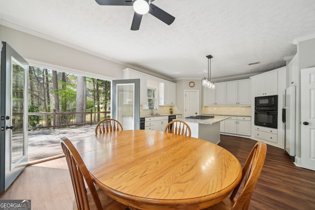 740 Trillium Ln, Lilburn, GA 30047 - dining area with ceiling fan, dark wood-type flooring, ornamental molding, a textured ceiling, and a chandelier