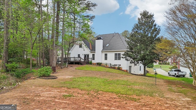 740 Trillium Ln, Lilburn, GA 30047 - rear view of house with a deck, a lawn, and a chimney