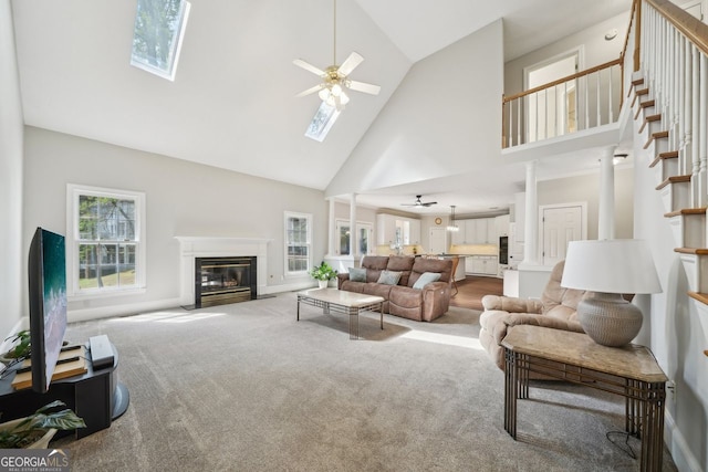 740 Trillium Ln, Lilburn, GA 30047 - living area with a skylight, ceiling fan, high vaulted ceiling, a fireplace with flush hearth, and carpet floors