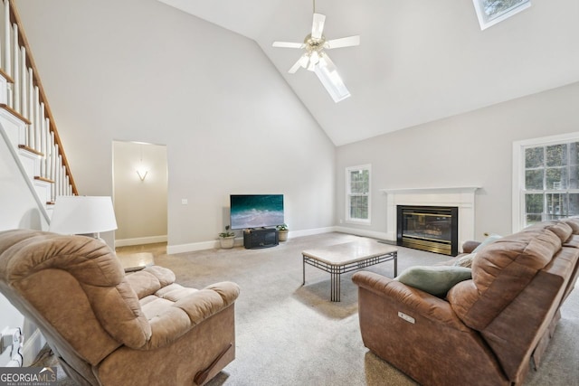 740 Trillium Ln, Lilburn, GA 30047 - carpeted living room featuring a skylight, high vaulted ceiling, healthy amount of natural light, a ceiling fan, and a glass covered fireplace