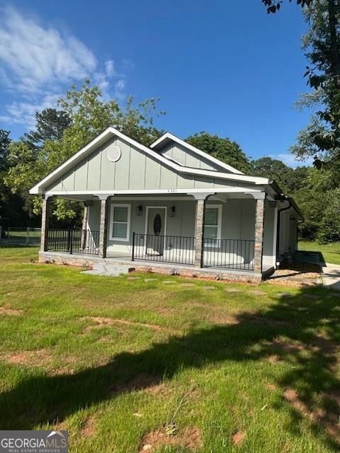 4321 Austell Powder Springs Rd SW, Powder Springs, GA 30127 - bungalow-style home with covered porch, a front yard, and board and batten siding