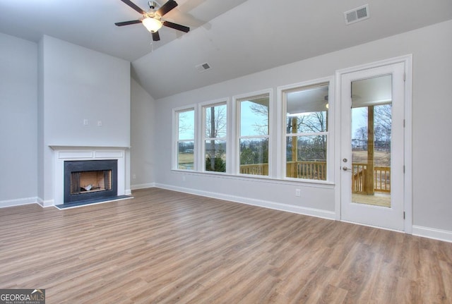 unfurnished living room with ceiling fan, visible vents, light wood-style floors, and a wealth of natural light