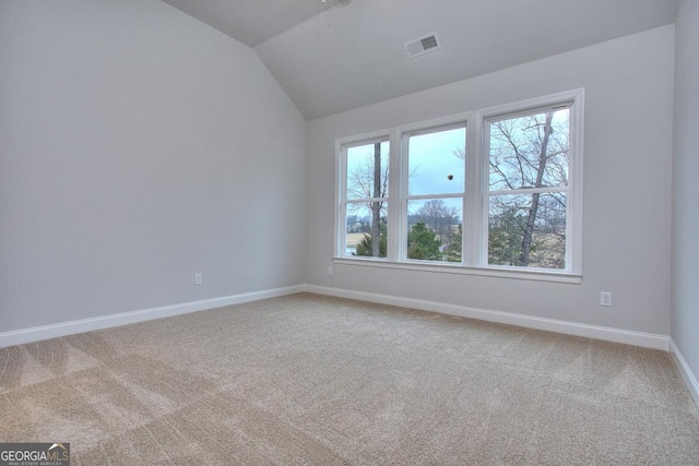 unfurnished room featuring carpet floors, baseboards, vaulted ceiling, and visible vents