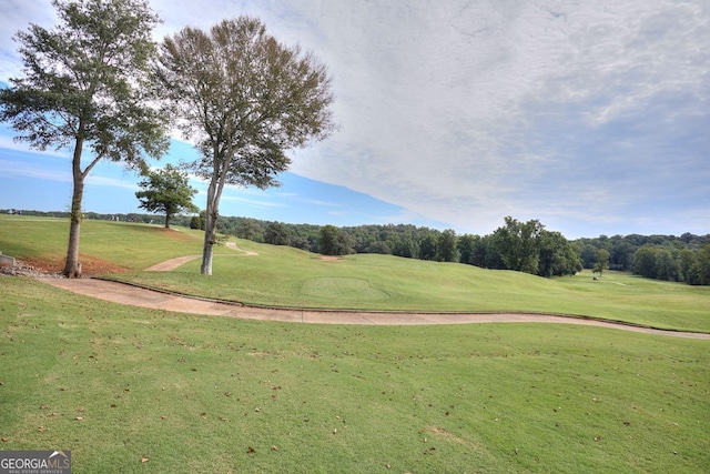 view of community featuring golf course view and a yard