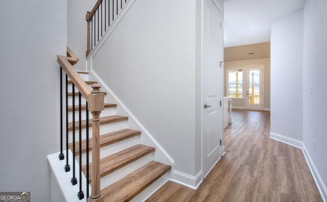 staircase with baseboards and wood finished floors
