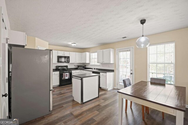 kitchen featuring visible vents, dark countertops, dark wood finished floors, white cabinetry, and black appliances