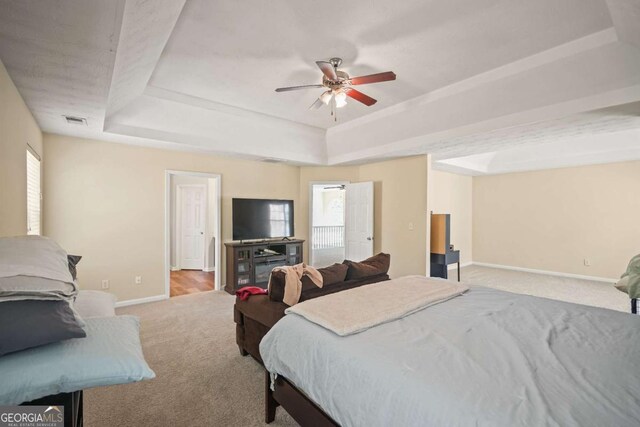 bedroom featuring baseboards, carpet flooring, visible vents, and a raised ceiling
