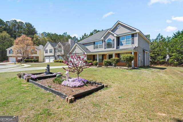traditional-style house with driveway, a garage, and a front lawn