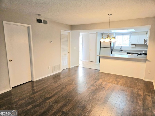 35 Rumson Ct SE, Smyrna, GA 30080 - kitchen featuring visible vents, wood finished floors, a peninsula, and a chandelier