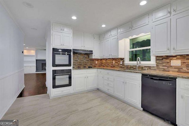 9415 Martin Rd, Roswell, GA 30076 - kitchen with black appliances, under cabinet range hood, light stone countertops, white cabinets, and recessed lighting